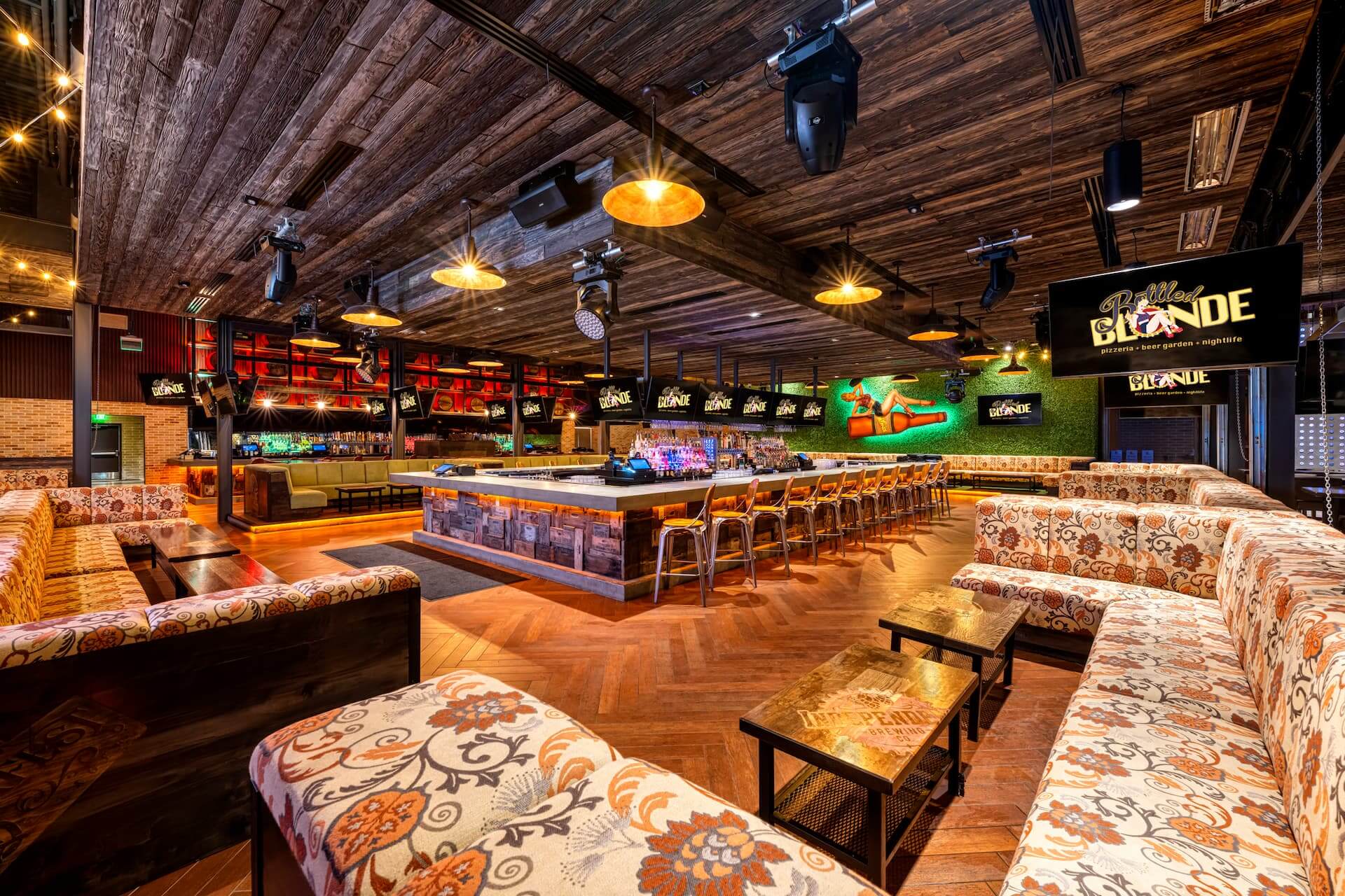Floral U-shaped lounge and wraparound island bar at Bottled Blonde Fort Worth, by Lion Craft