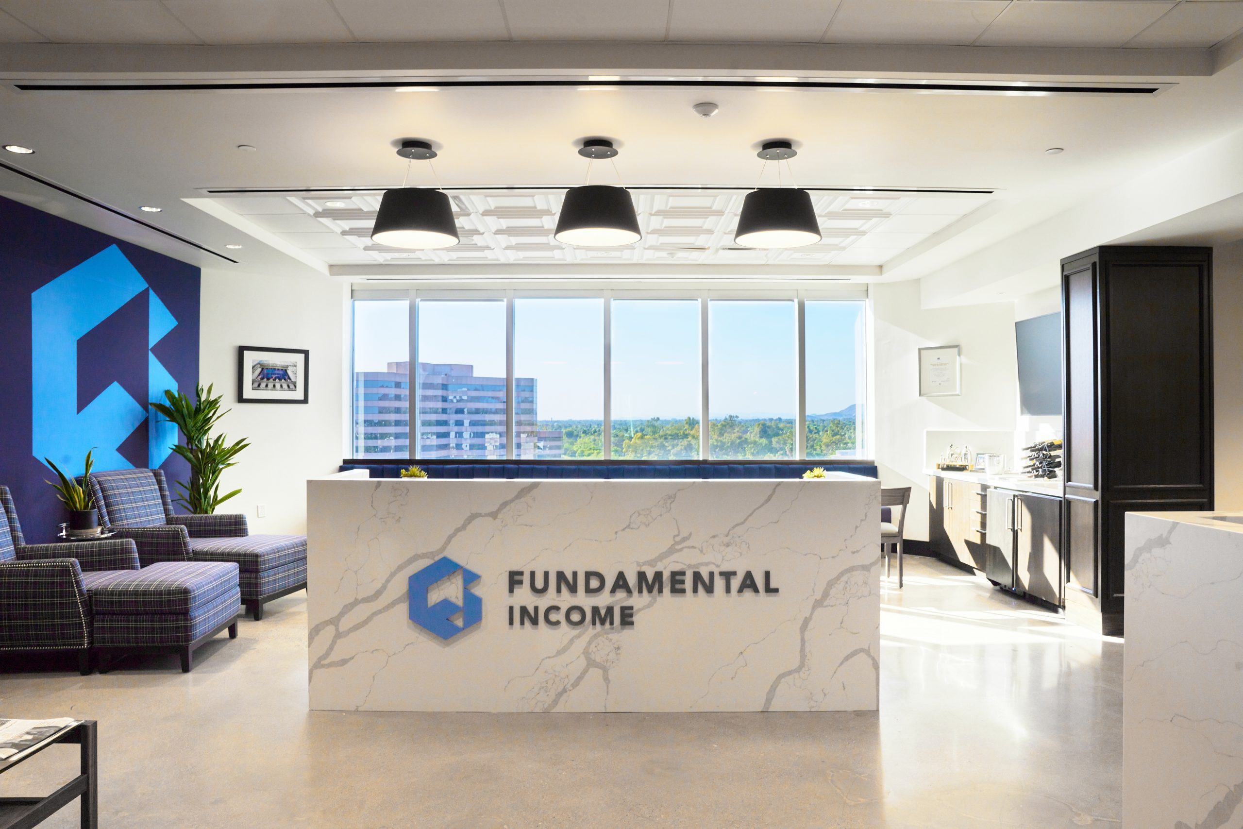 Waterfall quartz reception desk, paneled tall cabinet and coffee bar casework at the Fundamental Income office in Phoenix, by Lion Craft