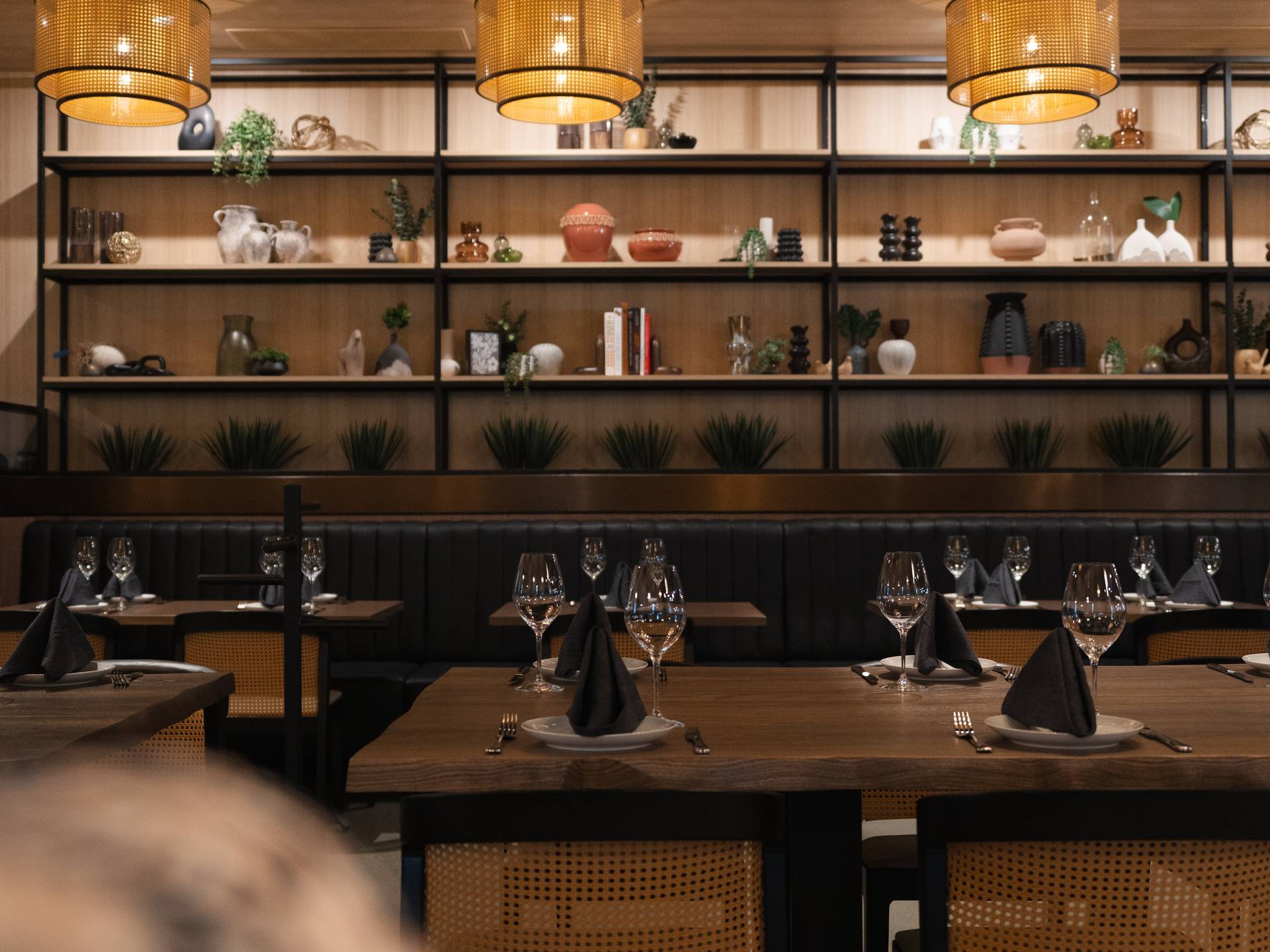 Channel-tufted banquette and steel display shelving at Quiriego Scottsdale by Lion Craft