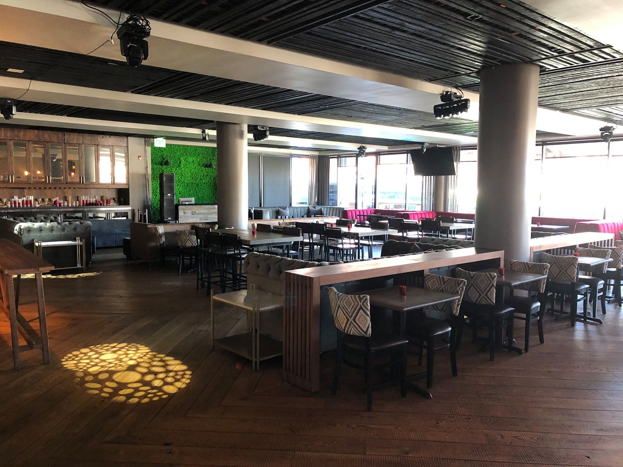 Rooftop lounge with communal tables and tufted booths