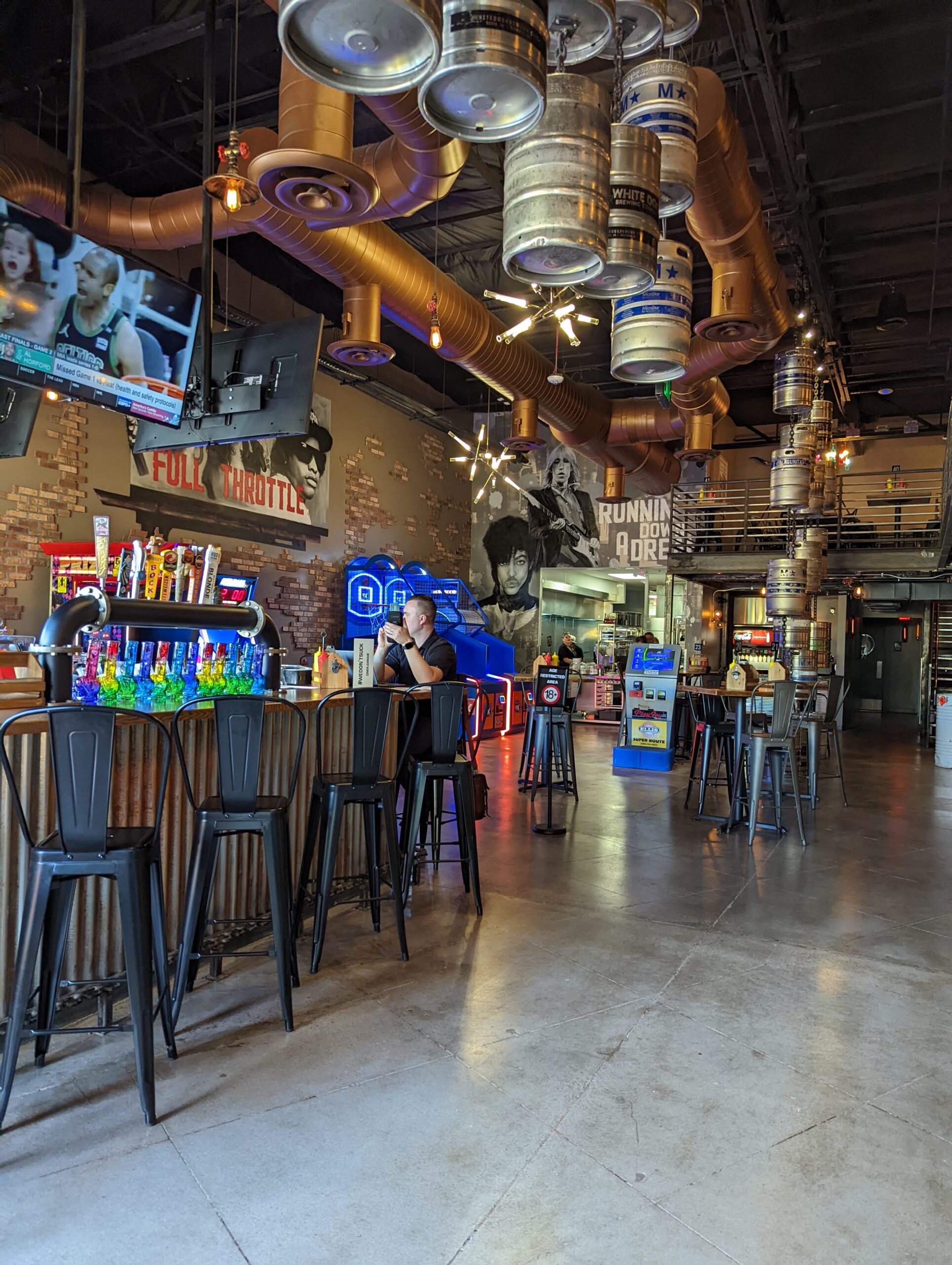 Industrial metal bar with custom keg light fixtures and metal stools