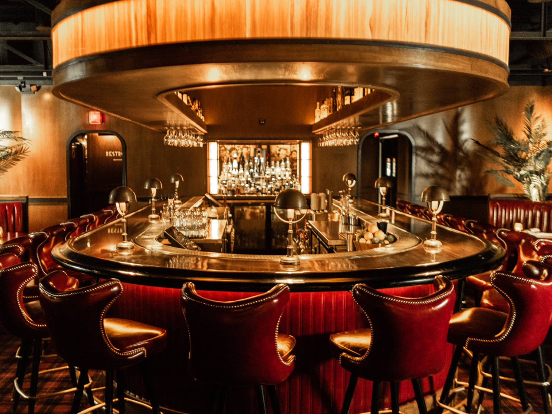 Oval bar with red leather stools and illuminated canopy at Drake's Hollywood Scottsdale by Lion Craft